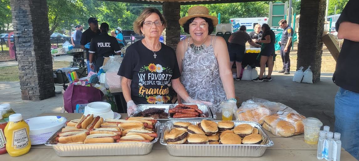 Joanne McGee (left) and Josephine Greco with the Journey Church give out hot dogs and burgers.